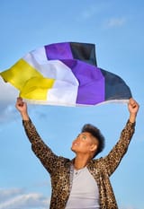 gender-non-binary-asian-person-holding-gender-non-binary-representative-flag-blowing-in-the