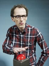 a-nerdy-guy-with-his-hand-poised-above-a-red-game-show-buzzer-FSIF00388