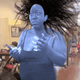 a banshee in a blue tank top is holding an iphone
