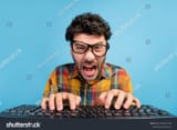 stock-photo-photo-of-angry-brunet-guy-type-keyboard-wear-eyewear-checkered-shirt-isolated-on-blue-color-2190331303