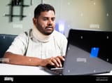 fat-man-with-neck-brace-working-on-laptop-due-to-neck-pain-during-work-from-home-concept-of-overworking-and-unhealthy-food-habits-during-coronavirus-2H601DD