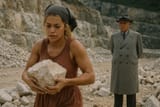 Rita Ora lifts rocks while Enver Hoxha watches