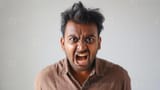 angry-young-man-with-wild-hair-yelling-in-brown-shirt-posing-for-studio-portrait-with-white-background-photo[1]