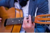 street-music-art-male-musician-playing-guitar-outdoors-cigarette-burn-headstock-selective-focus-street-music-art-male-201183468