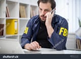 stock-photo-fbi-agent-talking-on-mobile-phone-in-office-625372325