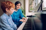 piano-teacher-woman-teaching-little-boy-home-piano-lessons-family-lifestyle-spending-time-together-indoors-children-with-musical-virtue-artistic-curiosity-educational-musical-activities_213512-703