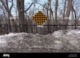 a-black-and-yellow-checkered-warning-sign-at-the-end-of-a-road-DY0JHR