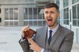 businessman-crying-holding-his-empty-wallet-110968727-1281997580