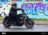 fat-obese-motorcycle-rider-riding-past-graffiti-on-southend-seafront-during-the-unofficial-southend-shakedown-motorbike-rally-overweight-MANM9H