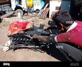 district-katni-india-december-14-2019-an-indian-village-mechanic-repairing-truck-engine-at-open-automobile-workshop-field-2CPBG5G