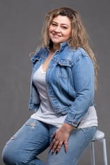 beautiful-fat-woman-denim-jacket-looks-camera-smiles-gray-background_186673-223