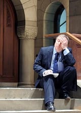 peter_hitchens_holding_his_head_sad_on_some_stairs