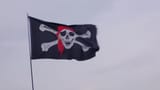 depositphotos_284964294-stock-video-pirate-flag-jolly-roger-hanging