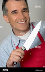 portrait-of-a-mid-adult-man-holding-a-kitchen-knife-and-smiling-2EFF444
