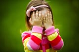 Baby-is-playing-hide-and-seek-hiding-face