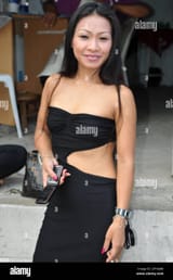 a-smiling-thai-woman-standing-outside-a-bar-in-the-sukhumvit-road-area-in-bangkok-thailand-2PYKJM8