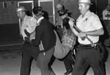woman carried away by police during the dixmoor riots