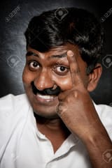 9265240-handsome-indian-man-with-moustache-and-raise-eyebrow-smiling-and-looking-at-camera-close-up