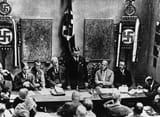 Adolf Hitler (standing) delivers a speech on the occasion of the refoundation of the NSDAP in February of 1925 with Blood Flag