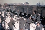 German Wehrmacht soldiers having a snowball fight in a train yard while awaiting deployment somewhere in France. 1944