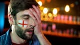 displeased-male-football-fan-english-flag-cheek-making-facepalm-gesture-stock-photo-151822691