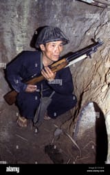 vietnam-war-a-viet-cong-soldier-crouches-in-a-bunker-with-an-sks-rifle-E1C41H