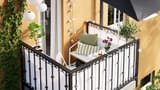 a-small-balcony-on-a-yellow-apartment-building-a-white-sofa--c1f96de1177ecfedc73a9651dd94ecf0