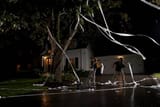 two-boys-throwing-toilet-paper-into-tree-in-front-of-house-night