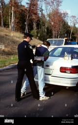 1990s-police-officer-arresting-cuffing-motorist-for-drunk-driving-D11A3M