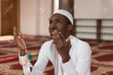 37571571-muslim-man-making-traditional-prayer-to-god-while-wearing-a-traditional-cap-dishdasha