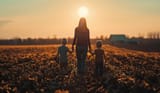 woman-two-children-walking-through-field-sunset_116317-45380