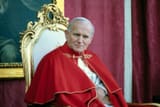 Pope-John-Paul-II-sitting-on-a-chair-with-a-portrait-of-the-St-Theresa-of-Avila-in-the-background-during-his-visit-to-Avila-Spain-November-2-1982