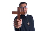 priest-holding-cross-of-wood-praying