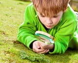 child with magnifiyihg glass