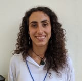 Moortuguese (and Milan, Lombardy, Italy) - Woman with curly hair smiling and wearing a white shirt