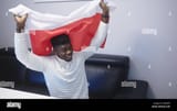 young-happy-black-man-man-with-polish-flag-watching-footbal-game-on-tv-high-quality-photo-2D85JEP