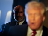 u-s-secretary-of-commerce-howard-lutnick-stands-next-to-u-s-president-donald-trump-as-he-speaks-with-journalists-onboard-air-f