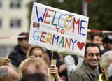 people-welcome-refugees-with-a-banner-reading-welc-1441642393888