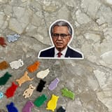 1749250946_imagen_a_thin_plasticine_sticker_of_a_renegade_political_leader_of_2025_peels_forward_off_of_a_slab_of_mica_very_poorly_painted_on_its_naturally_crystallized_layers_with_each_of_the_pantone_
