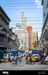 a-man-cyclkes-past-a-group-of-boys-in-this-general-view-of-life-in-a-street-in-central-dar-es-salaam-tanzania-2WJW4E6