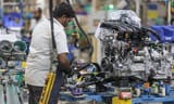An employee works on an engine block on the assembly line at a manufacturing plant in Chennai, India