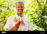 indian-man-holding-bouquet-and-looking-at-camera-2J77JD6