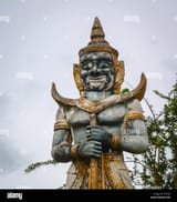 an-evil-god-statue-under-gray-sky-at-khmer-buddhist-temple-in-an-giang-KT0Y3J