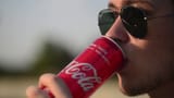 videoblocks-young-man-drinks-soda-coca-cola-opens-a-metal-jar-evening-in-city-urban-landscape_hb9bwibow_thumbnail-1080_01-1081653361