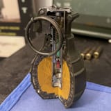Håndgranat_gjennomskåret_splintgranat_(uten_sikringsarm)_Fragmentation_hand_grenade_cutaway_model_Explo...sfilled_Pin-and-pineapple-design_triggering_pin_safety_ring_(without_lever)_Færder_museum_Torås_fort_Tjøme_Norway_2021_1
