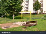 stock-photo-carpet-beater-and-bench-apartment-building-in-the-distance-1889143201