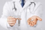 20859729-picture-of-doctor-hands-giving-white-pills-and-glass-of-water_jpg