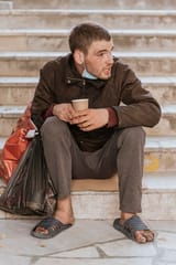 front-view-homeless-man-stairs-holding-cup-plastic-bag_23-2148760778