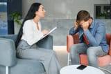psychology-mental-therapy-and-people-concept-woman-psychologist-talking-to-sad-young-man-patient-at-psychotherapy-session-photo