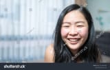stock-photo-close-up-to-confident-young-asian-small-eye-woman-is-smiling-in-her-bedroom-2116369763